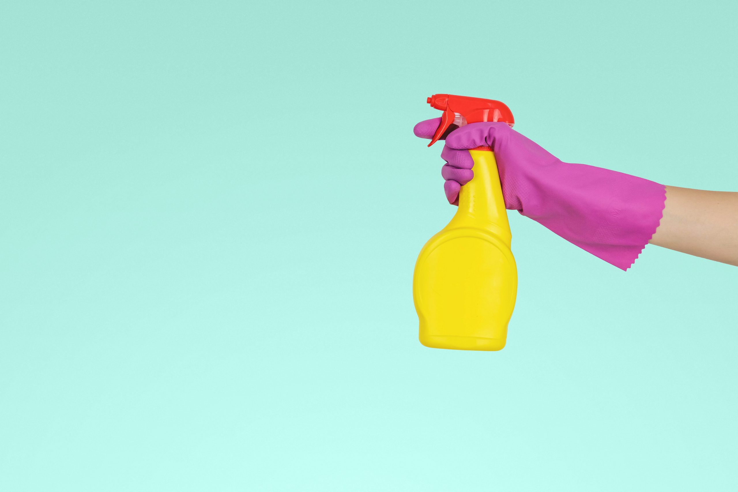 Gloved hand holding a cleaning bottle