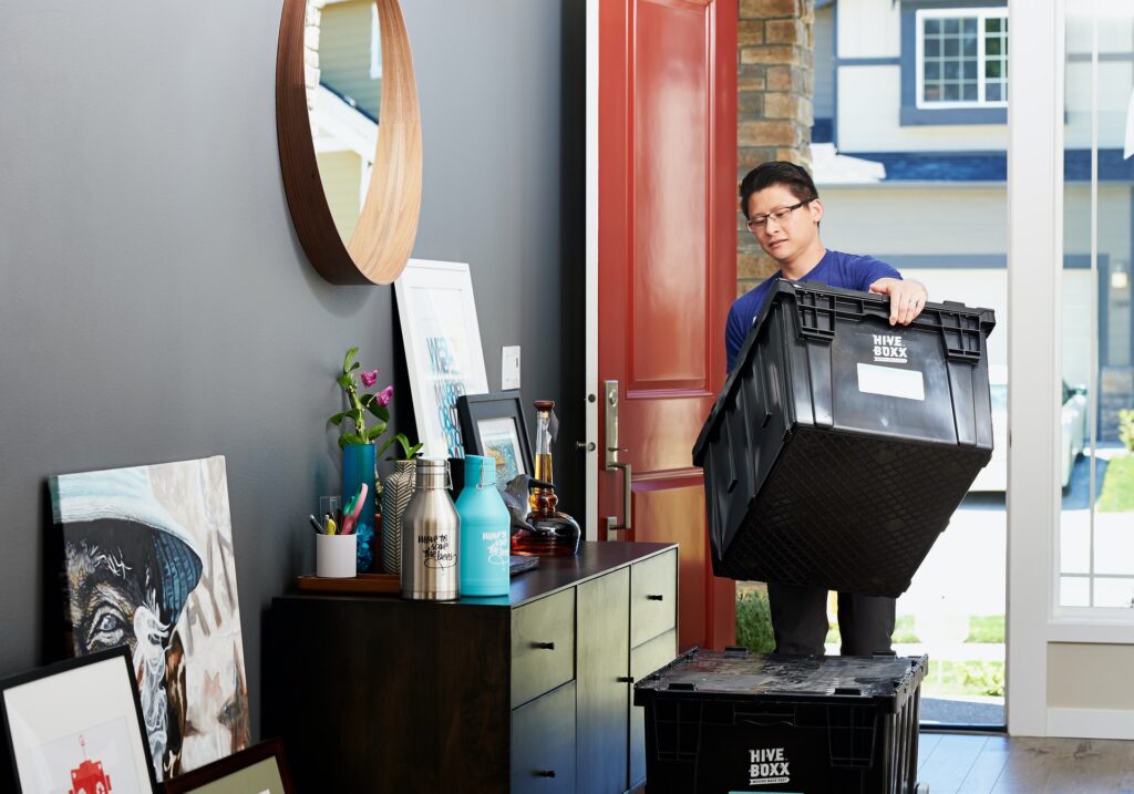 Man carrying a moving box into his new apartment