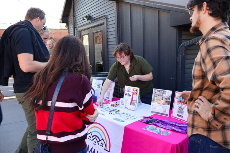 A table with information on Omaha ForUs at a community barbecue