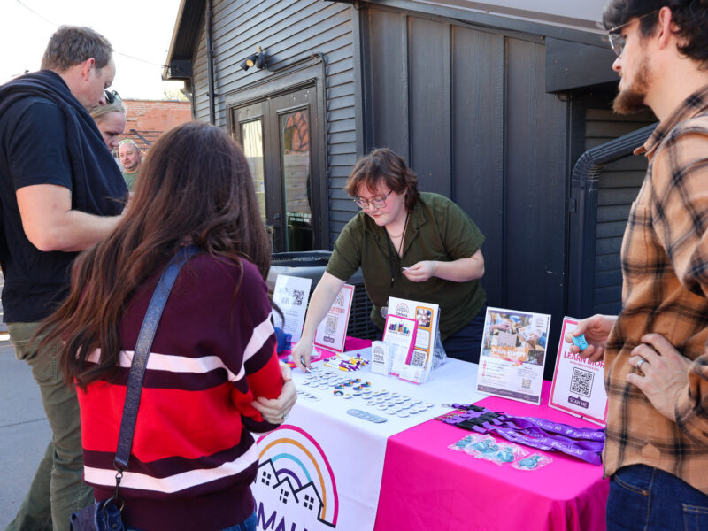 A table with information on Omaha ForUs at a community barbecue