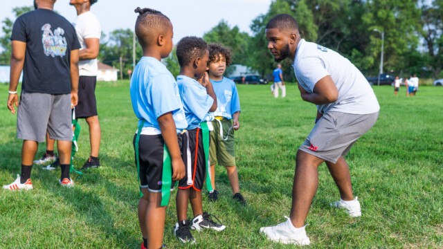 A coach talks to Urban Flag Football players on July 16, 2021. Photo by Chris Bowling.