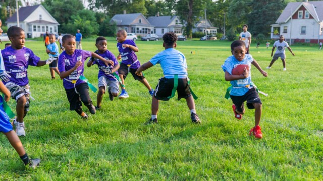 An Urban Flag Football League player sprints past tacklers at a game on July 16, 2021. Photo by Chris Bowling.