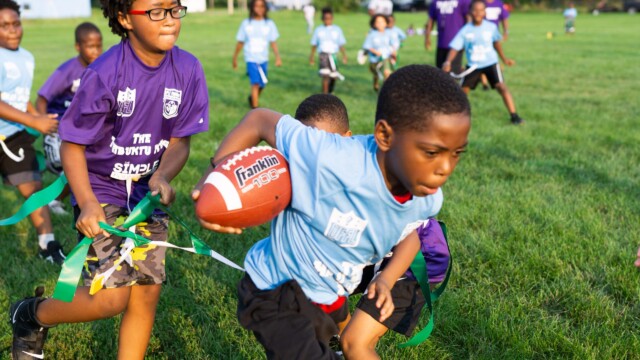 An Urban Flag Football League player sprints past tacklers at a game on July 16, 2021. Photo by Chris Bowling.