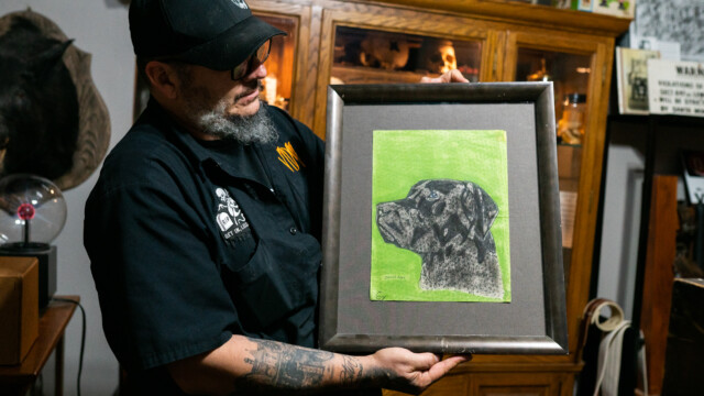 Derek Everhart holds up a Ted Bundy original, one of many oddities at Voodoo Odd Shop. Photo by Chris Bowling on Sept. 14, 2022.